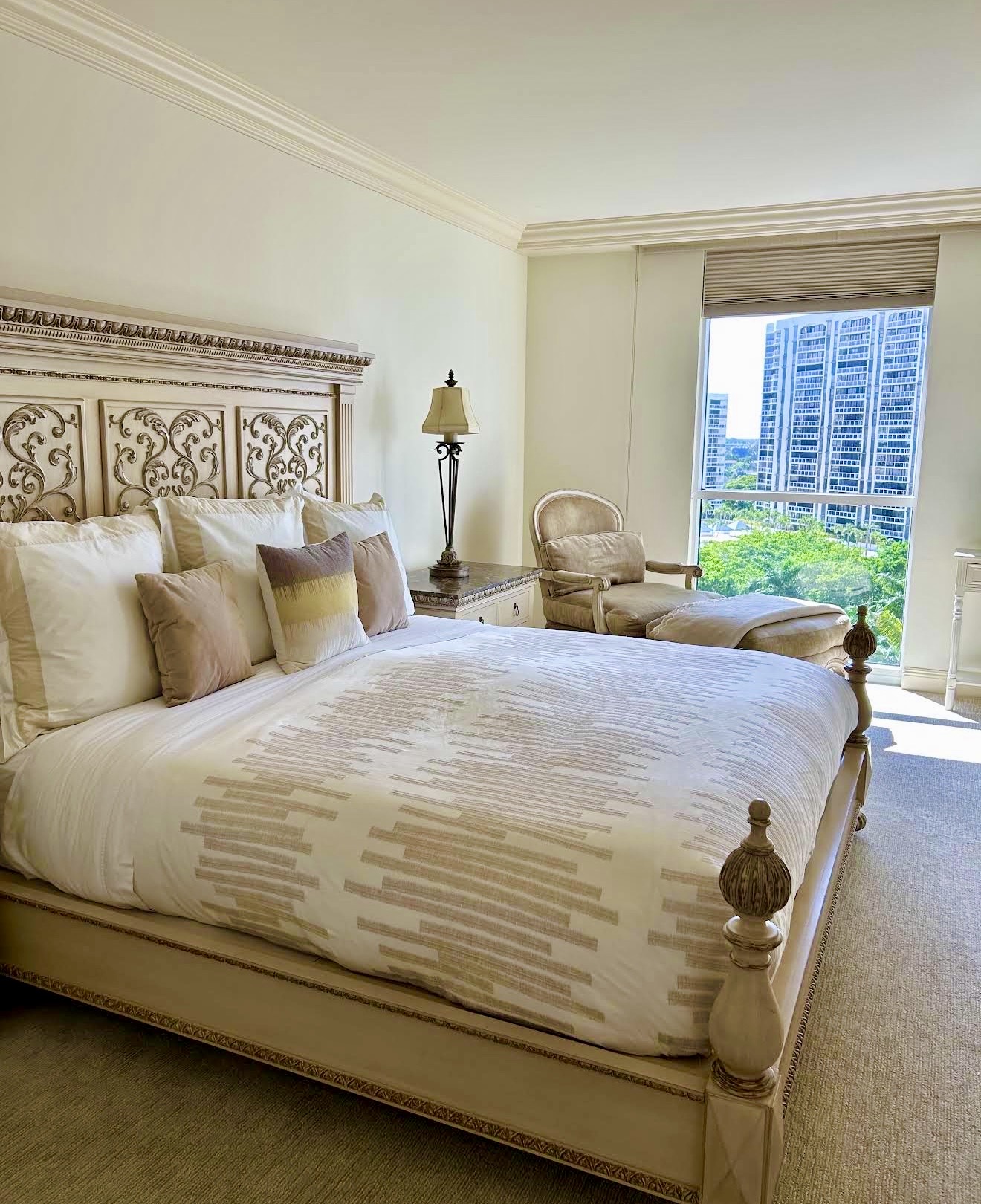 A luxurious, neatly made bedroom with soft morning light